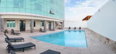 a swimming pool in front of a building at Hotel Retamayo in Ica