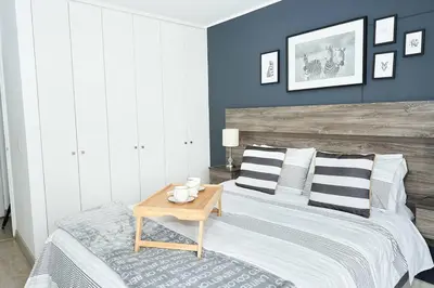 a bedroom with a bed with a wooden headboard and a table at Beautiful cozy Apt Barranco / Miraflores Peru in Lima