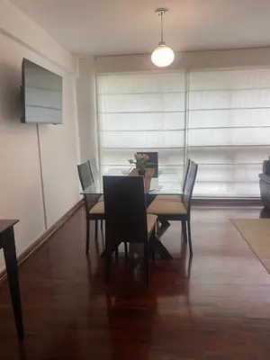 a dining room with a glass table and chairs at Apartamento Temporal en Miraflores in Lima