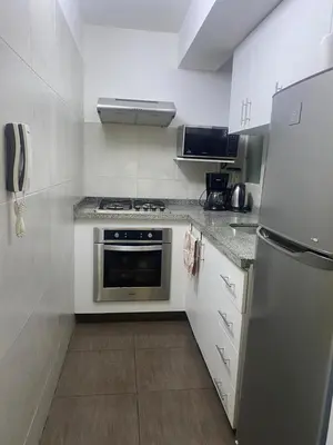 a kitchen with a stainless steel stove and refrigerator at Apartamento Temporal en Miraflores in Lima