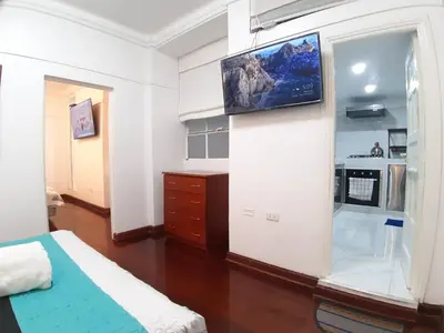 a bedroom with a tv hanging on a wall at APARTAMENTO LINDO - A 2 Cuadras de la Plaza de Armas y del Palacio de Gobierno in Lima