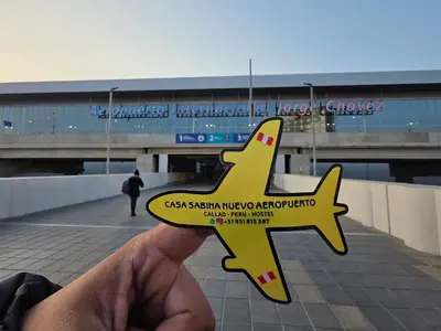 a person holding up a small yellow airplane sign at Sabina aeropuerto hostel in Lima