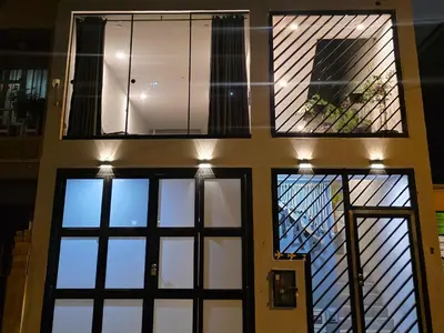 a house with three windows and a balcony at Sabina aeropuerto hostel in Lima