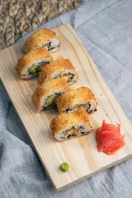 a wooden cutting board with six sushi rolls on it at Hotel California Urubamba in Urubamba