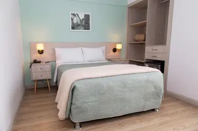 a bedroom with a large bed and a nightstand with a bed sidx sidx sidx at Hotel San Blas in Lima