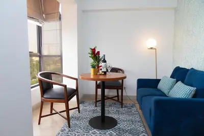 a living room with a table and a blue couch at Hotel San Blas in Lima