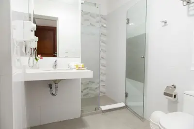a white bathroom with a sink and a shower at Hotel San Blas in Lima