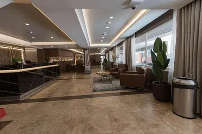 a lobby with a waiting area with chairs and a plant at Hotel Presidente Huancayo - Asociado Casa Andina in Huancayo