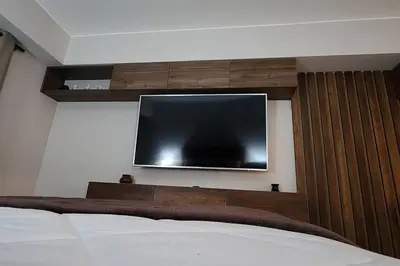 a flat screen tv on a wall with a bed at Departamento Zona Céntrica, de estreno in Lima