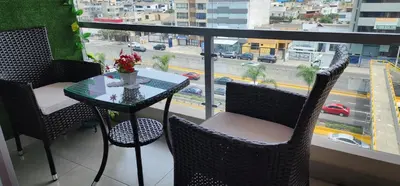 a table and chairs on a balcony with a view of a city at Departamento Zona Céntrica, de estreno in Lima