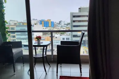 a balcony with a table and chairs and a view of a city at Departamento Zona Céntrica, de estreno in Lima