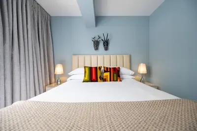 a bedroom with a large white bed with two lamps at * Casma Residence * Private Terrace & Grill & HVAC in Lima