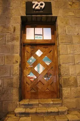 a wooden door in a brick building with a sign on it at Hotel Presidente Huancavelica - Asociado Casa Andina in Huancavelica