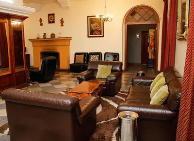 a living room with leather furniture and a fireplace at Hotel Presidente Huancavelica - Asociado Casa Andina in Huancavelica