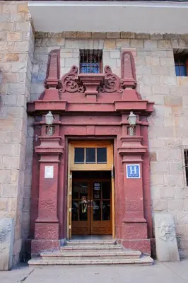 a red building with a door and a balcony at Hotel Presidente Huancavelica - Asociado Casa Andina in Huancavelica