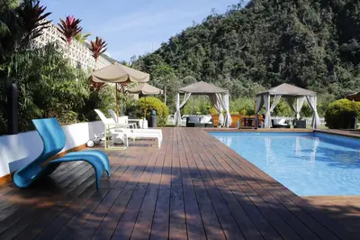 a pool with chairs and umbrellas on a wooden deck at Hotel Presidente Selva in La Merced