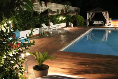 a swimming pool at night with a wooden deck and a swimming pool at Hotel Presidente Selva in La Merced