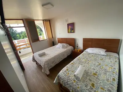 a hotel room with two beds and a balcony at HOTEL HACIENDA SUBTANJALLA CASABLANCA in Ica