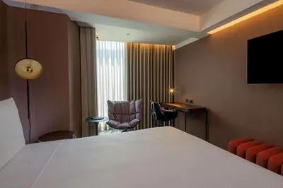 a hotel room with a bed and a chair at Doubletree By Hilton Lima San Isidro in Lima