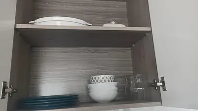 a cupboard with a bowl and a plate and dishes at Vive y trabaja con estilo en San Miguel, moderno departamento de 2 dorms con balcon in Lima