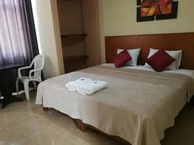 a bedroom with a bed with two towels on it at Hostal Aventura Total Perú_lunahuana in Lunahuaná
