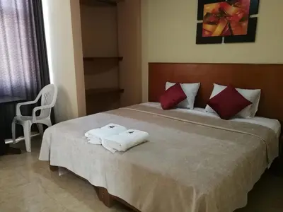 a bedroom with a bed with two towels on it at Hostal Aventura Total Perú_lunahuana in Lunahuaná