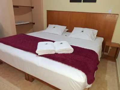 a hotel room with a bed with towels on it at Hostal Aventura Total Perú_lunahuana in Lunahuaná