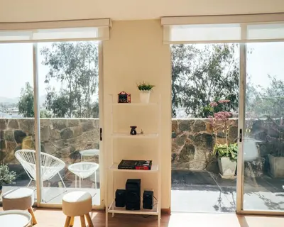 a living room with sliding glass doors and a book shelf at Acogedor departamento con amplia terraza in Lima