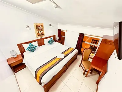 a bedroom with a bed and a desk and a computer at Libertrek Centro Inn in Cusco