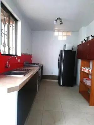 a kitchen with a black refrigerator and red walls at Amplia Casa de Campo con Piscina en Cieneguilla in Cieneguilla