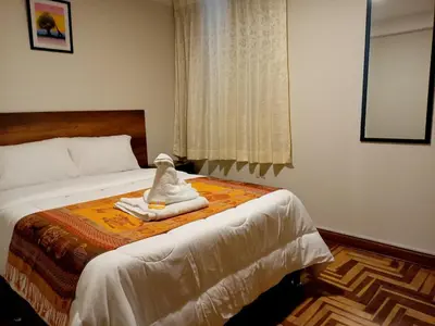 a bedroom with a bed with towels on it at Hostel Tupac Yupanqui House in Cusco