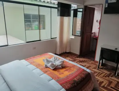 a room with a bed with a bow on it at Hostel Tupac Yupanqui House in Cusco