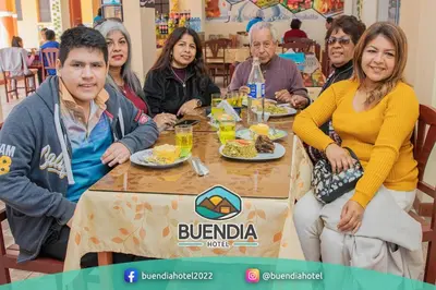 a group of people sitting around a table eating food at BUENDIA HOTEL in Pueblo Viejo