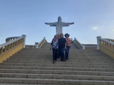 three women walking up the stairs to the christ redeemer statue at BUENDIA HOTEL in Pueblo Viejo