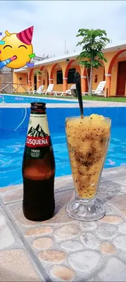 a bottle of beer sitting next to a drink at BUENDIA HOTEL in Pueblo Viejo