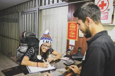a woman sitting at a desk with a party hat at Tupac Lima Airport in Lima
