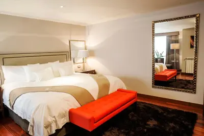 a bedroom with a large bed and a mirror at Atiq Boutique Hotel in Cusco