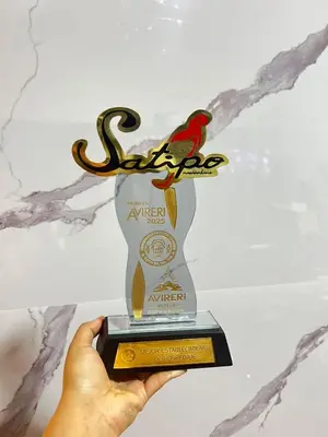 a hand holding up a trophy with a bird on it at Hotel Mayros in Satipo