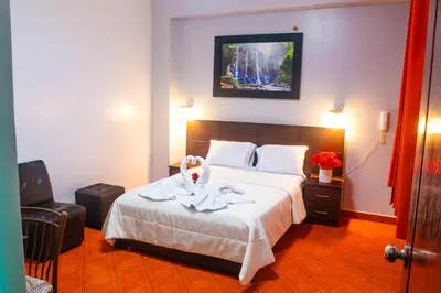a hotel room with a bed with a towel on it at Hotel Mayros in Satipo