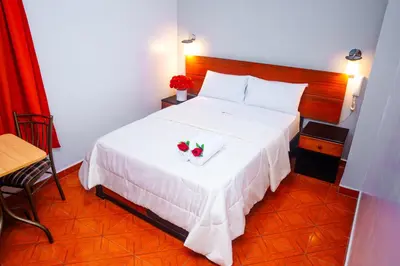 a bedroom with a white bed with two strawberries on it at Hotel Mayros in Satipo
