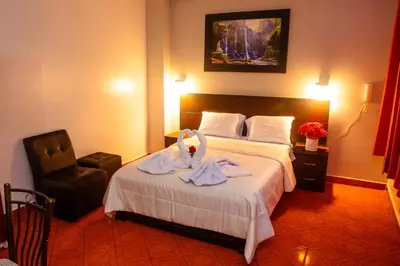 a hotel room with a bed with a swan on it at Hotel Mayros in Satipo