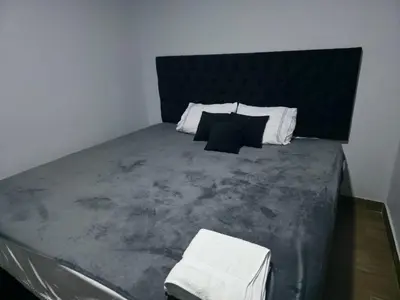 a bedroom with a large bed with black and white pillows at Casa sabina nuevo aeropuerto in Lima