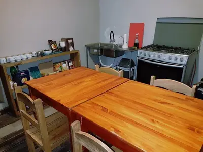 a kitchen with a wooden table and a stove at Nico Homes in Cusco
