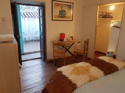 a bedroom with a bed and a table and a table and chairs at Nico Homes in Cusco