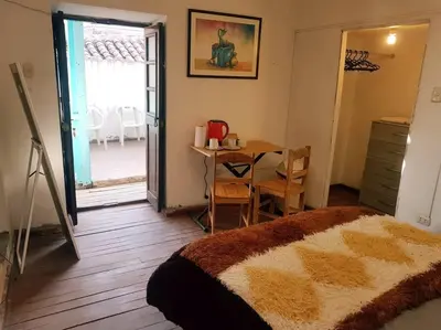 a room with a bedroom with a table and a bed at Nico Homes in Cusco