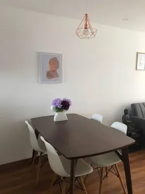 a dining room table with white chairs and a vase of flowers at Hermoso y amplio departamento en zona tranquila en Jesús Maria in Lima
