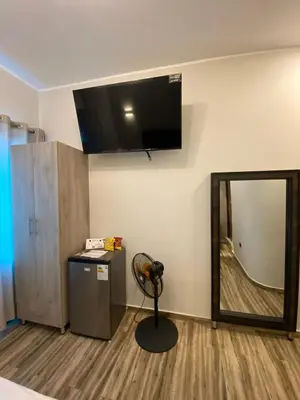 a room with a mirror and a television on the wall at Ciudad Del Sol Hostel in Ica
