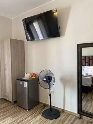a room with a fan in a room with a bed at Ciudad Del Sol Hostel in Ica