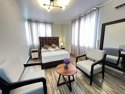 a bedroom with a bed and a table and chairs at Ciudad Del Sol Hostel in Ica