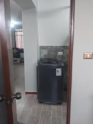 a small black refrigerator in a room with a hallway at Departamento Céntrico y Acogedor in Huancayo